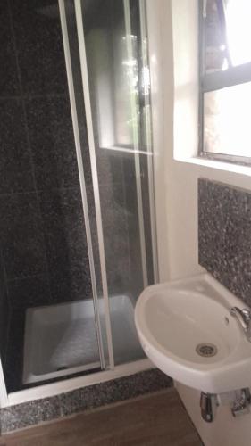 a bathroom with a shower and a sink at Rhulani Treetop Cottage in Marloth Park