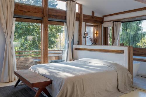 剑川县Shaxi Ancient Town Shiran Mountain Homestay的一间带床和大窗户的卧室