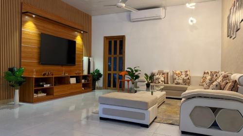 a living room with a couch and a tv at Muladdu Inn in Feydhoo