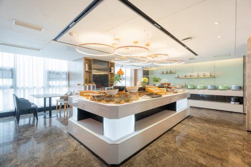 a kitchen with a counter with food on it at 沃德酒店滕州市政府火车站店 in Tengzhou