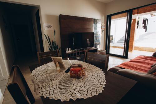 a living room with a table and a television at Villa Rio in Brotas