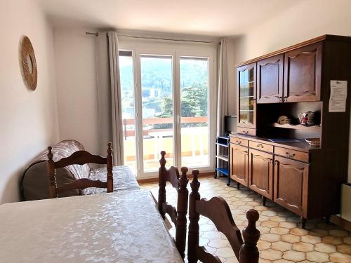 un salon avec un lit et une grande fenêtre dans l'établissement Port-Vendres : T2 calme avec parking, grande terrasse ensoleillée et proche du port - FR-1-309-215, à Port-Vendres