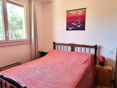 une chambre avec un lit avec une couverture rouge et une fenêtre dans l'établissement Port-Vendres : T2 calme avec parking, grande terrasse ensoleillée et proche du port - FR-1-309-215, à Port-Vendres