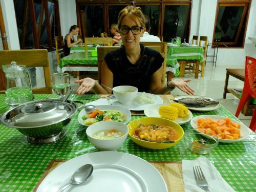 RinondoranTangkoko Macaca的一位女士坐在桌旁，桌上摆满了食物