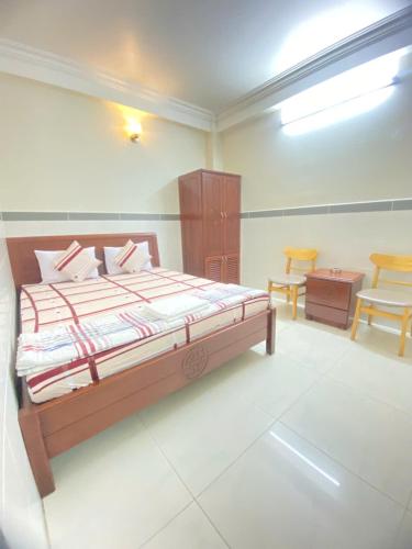 a bedroom with a bed and a table and chairs at Khách sạn Hoàng Hải in Ho Chi Minh City