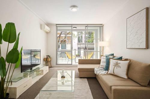 a living room with a couch and a tv at A Comfortable Studio Near Darling Harbour in Sydney