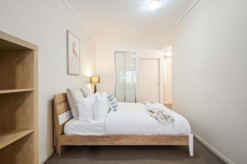 a bedroom with a bed with white sheets and pillows at A Comfortable Studio Near Darling Harbour in Sydney