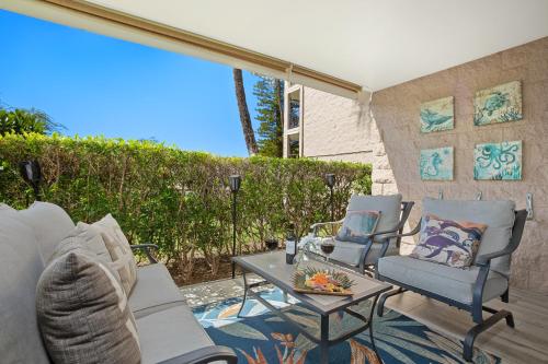 a patio with chairs and a table on a patio at Remodeled 1BR at Kihei Ali'i Kai with Free Parking! in Kihei