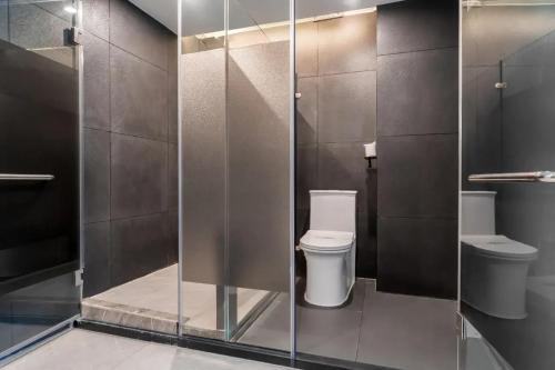a bathroom with two toilets and a glass wall at Yangshuo EMOJI YOUTH HOSTEL in Yangshuo