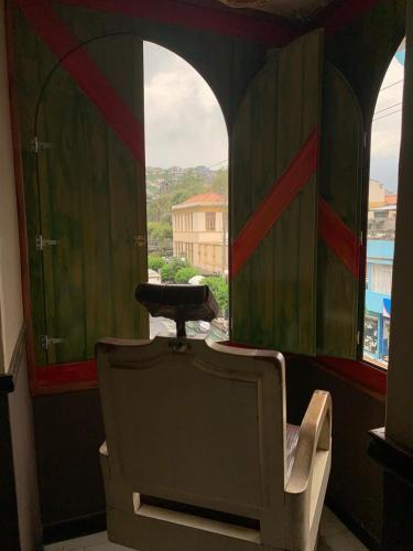 a chair sitting in a room with a window at Flying Donkey in Otavalo