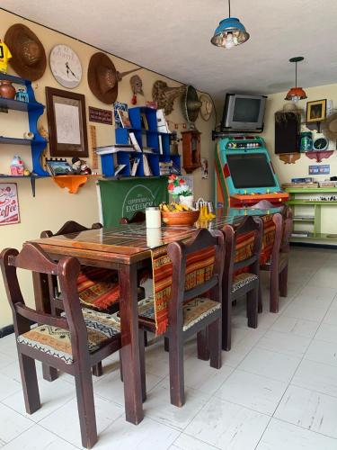 a dining room with a wooden table and chairs at Flying Donkey in Otavalo