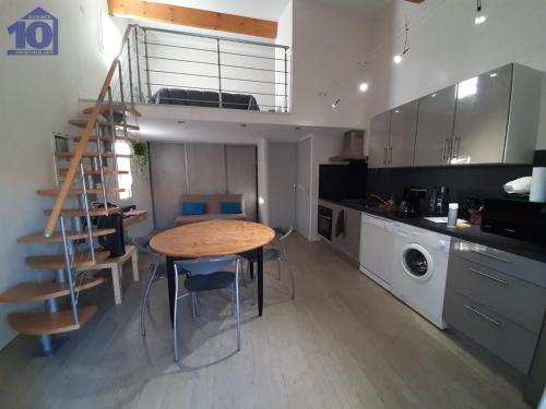 une cuisine avec une table et un escalier. dans l'établissement Pavillon à Valras-Plage, 4 pers, piscine, clim, parking, proche mer - FR-1-781-68, à Valras-Plage