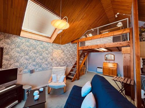 - un salon avec un canapé bleu et des lits superposés dans l'établissement Appartement pour 6 pers. à Autrans, proche ski - FR-1-737-95, à Autrans