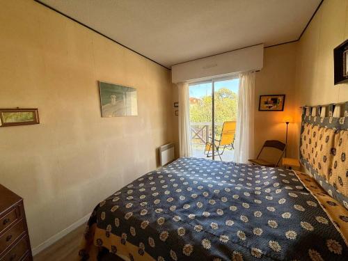 une chambre avec un lit et une grande fenêtre dans l'établissement Arcachon: Appartement proche plages avec balcon et parking - FR-1-433-136, à Arcachon