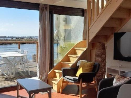 un salon avec un escalier et une grande fenêtre dans l'établissement Villa T3 avec climatisation près du lac à Le Barcarès - FR-1-782-75, au Barcarès