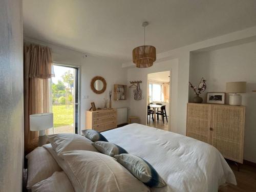 une chambre avec un grand lit avec des oreillers dessus dans l'établissement Maison 4* à Beg Meil, proche plage avec jardin, 3 chambres, parking - FR-1-481-177, à Fouesnant