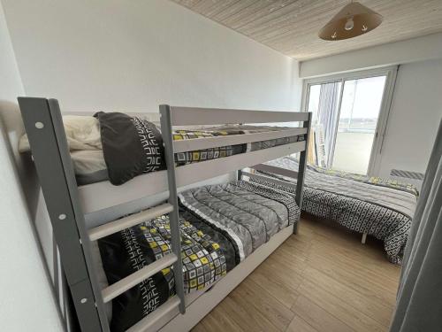 deux lits superposés dans une chambre avec fenêtre dans l'établissement Appartement Moderne Vue Mer, Dernier Étage, Parking Privé - FR-1-324A-71, à Saint-Hilaire-de-Riez
