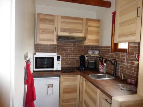 una cucina con lavello e microonde di Chalet confortable 45 m², 5 couchages avec jardin à Barcelonnette - FR-1-804-54 a Barcelonnette