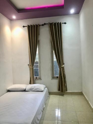 a bedroom with a bed and a window at Lombok Family Homestay in Masbagik