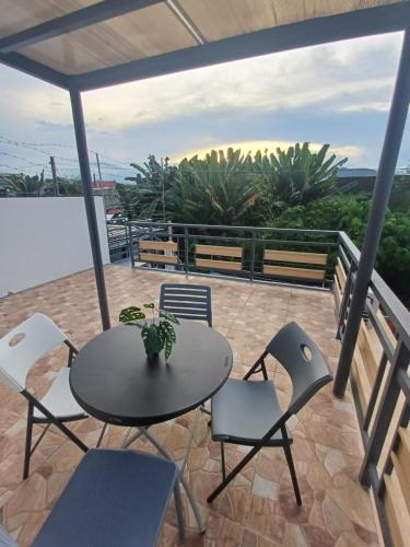a patio with a table and chairs on a balcony at BMF Homestay Jacuzzi in Tacloban