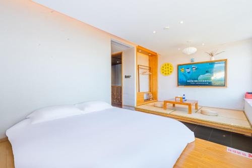 a bedroom with a large white bed in a room at Shenzhen Yusu Linting Seaview Inn Judiaosha Branch in Shenzhen