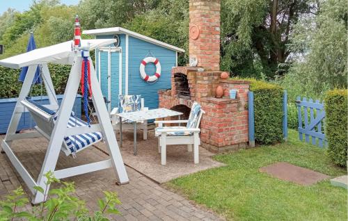 a backyard with a table and a house with a fire place at Ferienhaus Kummerow in Kummerow