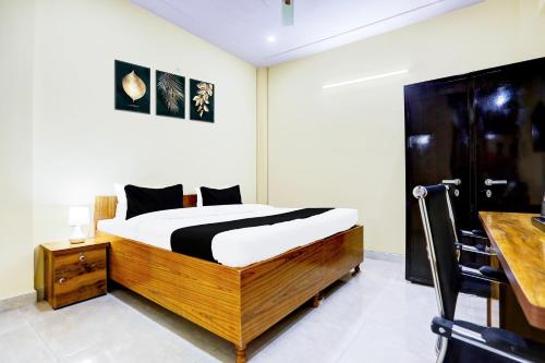 a bedroom with a bed and a desk at Hotel O Mother Touch in Indirapuram