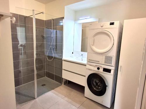 La salle de bains est pourvue d'un lave-linge et d'une douche. dans l'établissement Mimizan Plage: Appartement Neuf 6 Pers à 400m de l'Océan avec WIFI - FR-1-50-150, à Mimizan