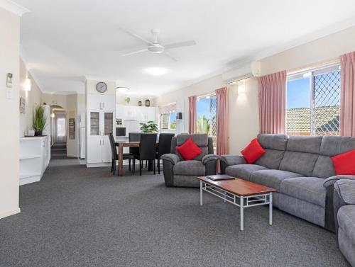 a living room with a couch and a table at Beachside 2-Bed Apt in Hervey Bay with Parking in Torquay