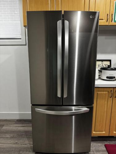 a stainless steel refrigerator in a kitchen at Gateway to Serenity-Welcome home in London