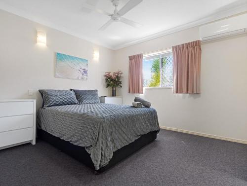 a bedroom with a bed and a window at Beachside 2-Bed Apt in Hervey Bay with Parking in Torquay