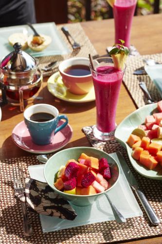 een tafel met fruitschalen en kopjes koffie bij Villa Bayad in Payangan