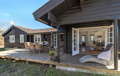 a house with a deck with a table and chairs at Four-Bedroom Holiday Home In Ebeltoft in Ebeltoft