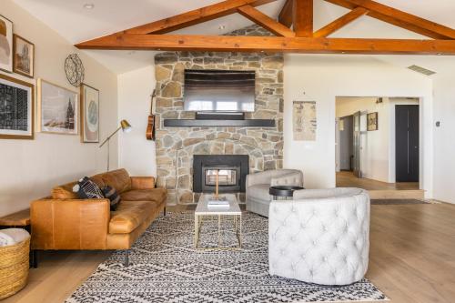a living room with a couch and a stone fireplace at Montebello Views in Cupertino