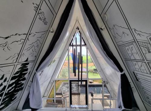 a window in a room with a wall with drawings on it at My Cabin by One Selah in Bustos