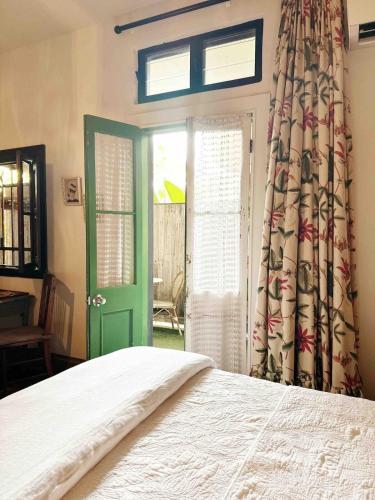 a bedroom with a bed and a green door at One Fabulous Room Brunswick Heads in Brunswick Heads