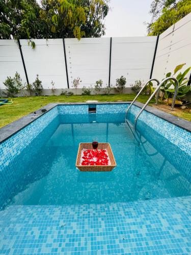a tray of strawberries in a swimming pool at Aura Farms - Private Pool Cottages in Rāmanagaram