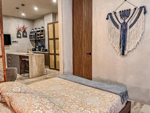 a room with a bed and a kitchen at Bagá 201 By Rotamundos in Playa del Carmen