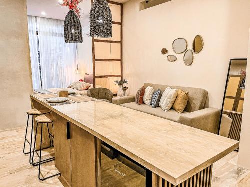 a kitchen with a large island in a living room at Bagá 201 By Rotamundos in Playa del Carmen