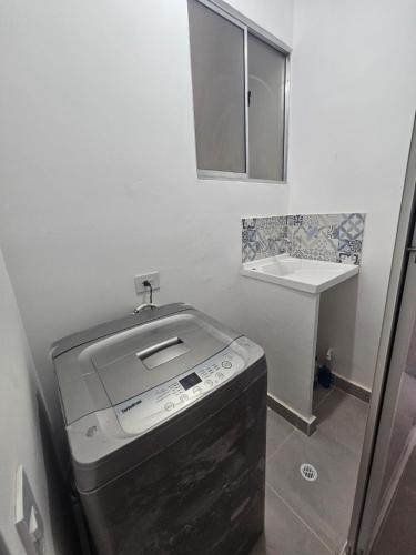 a small bathroom with a sink and a washing machine at Apartamento NIZA con aire acondicionado cerca al CC Mayales Plaza in Valledupar