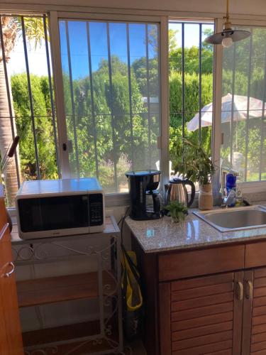 a kitchen with a microwave on a counter with a window at Mar 11 a 100 mtros del mar in Parque del Plata
