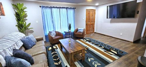 a living room with a couch and a table at 3Bd, King, Brkfst, Large TVs, WD, Sleeps 11, BBQ in Page