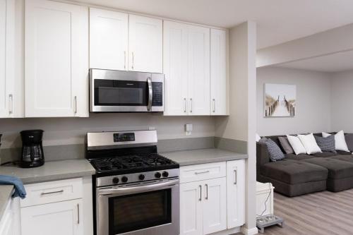 a kitchen with a stove and a microwave and a couch at Central San Diego 3BR Home Near Beaches in San Diego