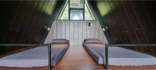 two beds in a small room with a window at My Cabin by One Selah in Bustos