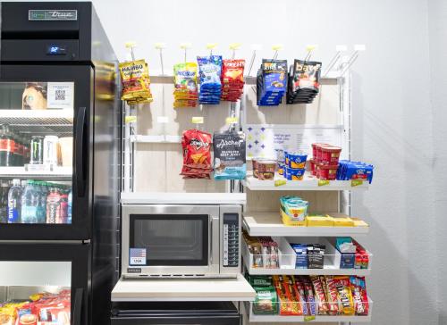 a refrigerator with a microwave and some food at Spark By Hilton Lafayette South in Lafayette