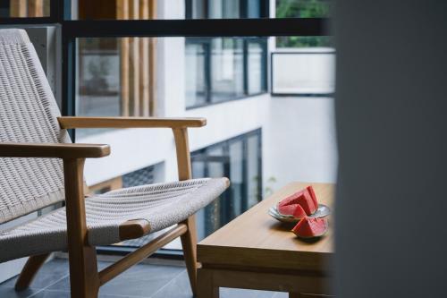 a chair and a bowl of watermelon on a table at 青城山喜遇安下私汤民宿 in Dujiangyan