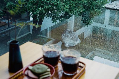 two drinks on a table with a tray of food at 青城山喜遇安下私汤民宿 in Dujiangyan
