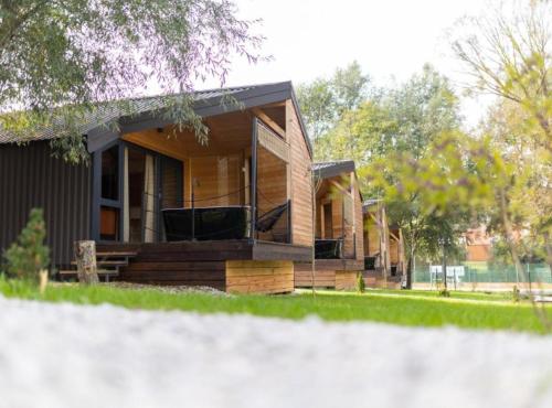 ein Holzhaus mit einer Veranda und einem Hof in der Unterkunft Halicanum Glamping Peaceful Retreat Resort in Sveti Martin na Muri