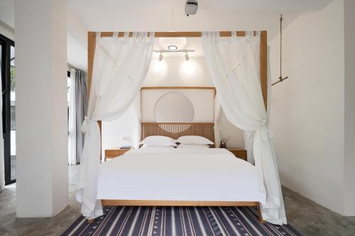 a bedroom with a white bed with curtains at 青城山喜遇安下私汤民宿 in Dujiangyan