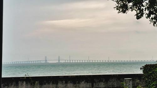 a bridge over the water with the ocean at Maritime Suites Penang in Jelutong